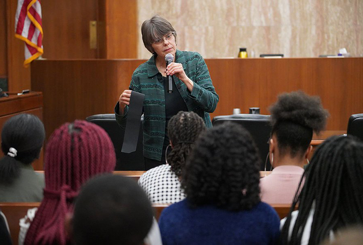 Mary Beth Tinker speaking with students during an activity at a courthouse.